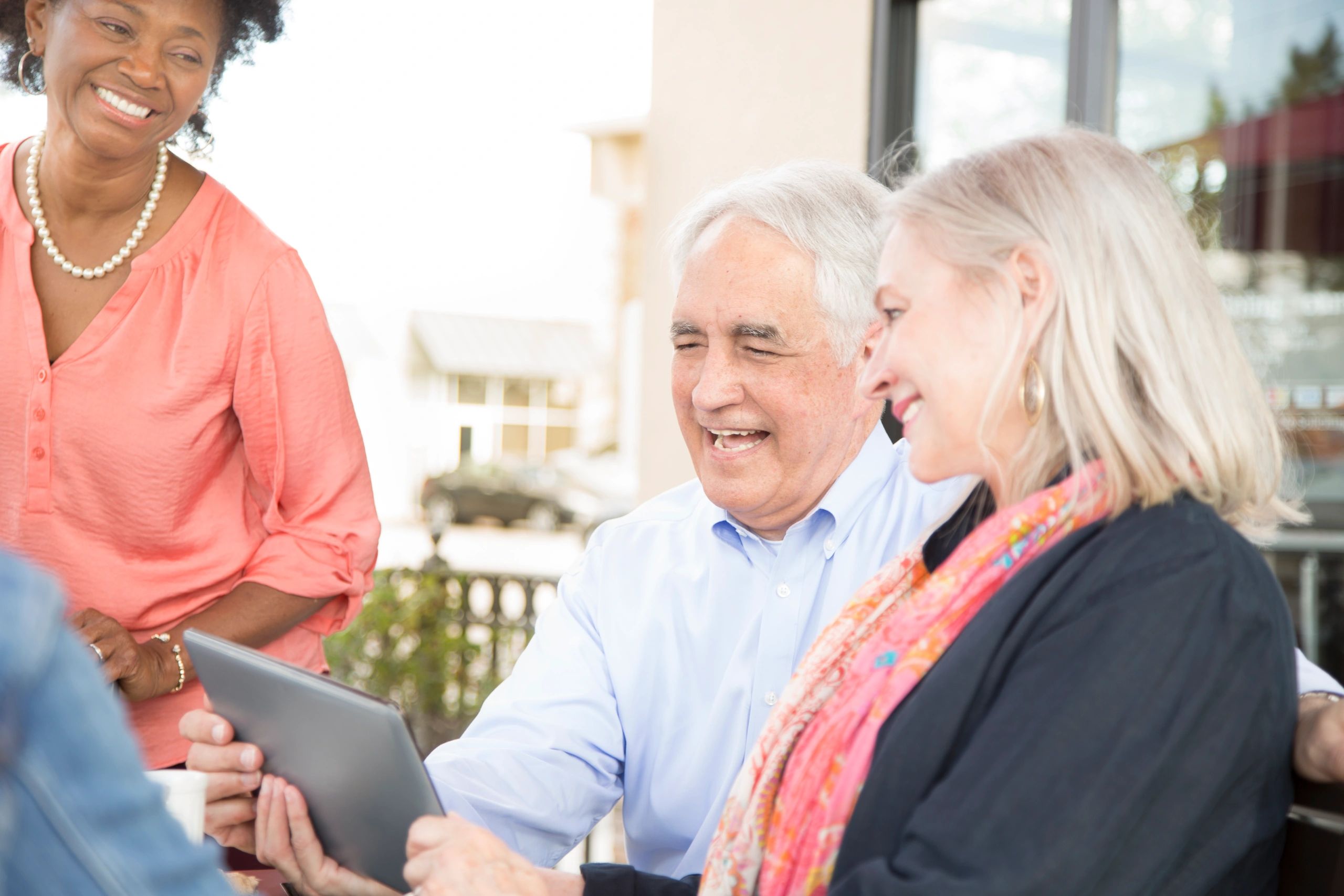 Assisted living staff and residents using a tablet together